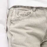 Pantalón de jean gris claro, de corte ancho y tiro alto, con cinco bolsillos.