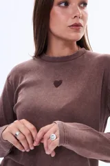 Remera de manga larga en color marrón con textura acanalada y un pequeño corazón bordado en el centro del pecho.
