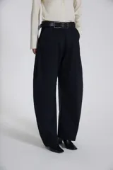 Pantalón negro de corte amplio con cinturón de cuero negro.
