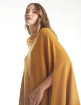 Poncho tejido de punto con terminación asimétrica y cuello holgado.