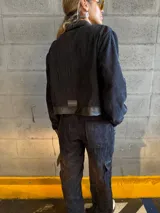 Conjunto negro de pana compuesto por una chaqueta con cuello de cuero sintético, cierre frontal con cremallera y bolsillos con solapa, y un pantalón de corte recto con bolsillos laterales.