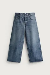 Jeans baggy fit de tiro medio, confeccionados en denim de algodón con efecto lavado. Presentan un diseño de cinco bolsillos, corte holgado y amplio en toda la pierna, con cierre frontal de botones.