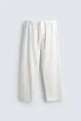 Pantalón de corte regular fit confeccionado en mezcla de algodón y lino. Presenta cintura elástica con cordón ajustable, cierre frontal con cremallera y botón, bolsillos laterales y bolsillo trasero de vivo con botón.