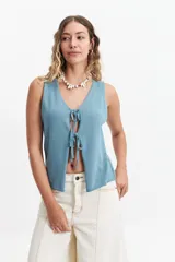 Chaleco tejido color lila con escote en V y lazo doble al frente.