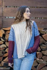 Sweater de punto con diseño de ochos y estilo patchwork, combinando paneles en colores terracota, marrón y beige. Presenta cuello redondo, mangas largas y costuras decorativas a la vista.