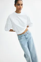 Jean de cinco bolsillos en denim de algodón con diseño de tiro alto y piernas amplias de corte holgado.