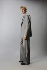 Blazer de corte regular confeccionada en tejido con lana, color gris. Presenta cuello con solapas de muesca, manga larga, bolsillos de vivo en el pecho y bolsillos de solapa en la cadera. Cuenta con cierre frontal de botones y aberturas en la espalda.