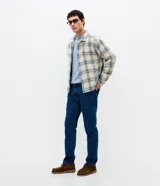Pantalón de jean slim color azul, con lavado medio y acabado uniforme. Cuenta con cintura con presillas, cierre frontal con botón y cremallera, y bolsillos funcionales en la parte delantera y trasera.
