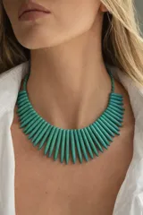 Collar corto de piedras color turquesa en forma de púas alargadas, unidas por cristalitos facetados.