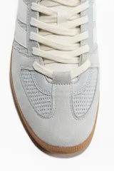 Championes de diseño urbano, en tonos celeste y gris, con detalles en blanco y suela de goma marrón.