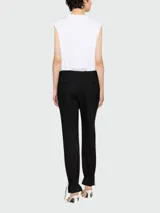 Remera blanca sin mangas de algodón con el logo de Balmain estampado en negro en el pecho y botones dorados en el hombro.