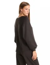 Buzo de corte holgado con sisa raglán y mangas largas con puños ajustados. Presenta un estampado sutil de animal print tono sobre tono y escote redondo a la base.