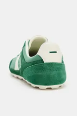 Zapatillas de estilo running con diseño en color verde y detalles en blanco y amarillo, confeccionadas con una combinación de materiales textiles y sintéticos, cierre de cordones y suela plana.