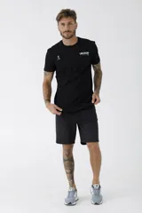 Remera negra de manga corta con cuello redondo. Presenta un estampado pequeño en el pecho con la palabra 'URUGUAY' y un logo gráfico adicional.