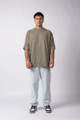 Remera de corte oversize con efecto de lavado gastado, confeccionada en algodón pesado. Presenta cuello redondo, mangas cortas con costuras visibles y un diseño amplio.