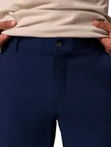 Pantalón chino Columbia de hombre, color azul marino, con tecnología Omni-Shield repelente al agua y manchas, tejido elástico, bolsillos laterales, bolsillo de seguridad con cremallera y trabilla multiusos.
