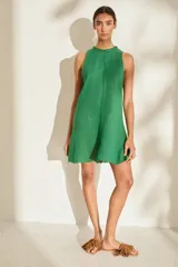 Vestido corto de lino italiano, sin mangas y con cuello redondo a la base. Presenta detalles desflecados en el cuello y costura central vertical.