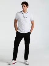 Polo blanco de piqué de algodón, corte clásico, manga corta con ribete azul marino, cuello con ribete azul marino, tapeta de dos botones y bolsillo de parche en el pecho con logo bordado.