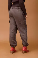 Pantalón cargo de tiro medio en color marrón, con diseño de silueta relajada, bolsillos laterales tipo cargo y puños elásticos en los tobillos.