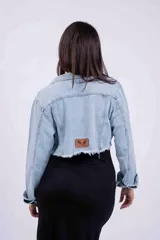 Campera de jean celeste de corte cropped, con cuello clásico, botones metálicos y mangas largas.