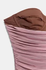 Corsé strapless con aros, confeccionado con una base de tela lisa color marrón y una capa superior de tul drapeado en color rosado.
