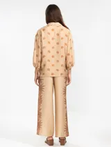 Pantalón palazzo negro con estampado de sirenas en color beige.