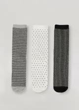 Pack de tres pares de medias de media caña con diferentes diseños: un par a rayas horizontales grises y negras, un par blanco con lunares negros y un par negro con diseño de espiga en blanco.