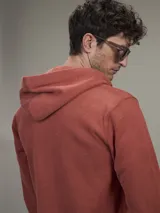 Buzo tipo hoodie con cierre frontal completo, capucha con cordones ajustables y bolsillos laterales. Confeccionado en tejido de algodón con textura jaspeada.