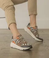 Zapatillas con estampado animal print de leopardo y cebra, con detalles en naranja y negro.