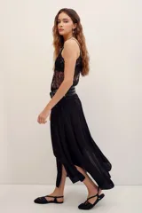 Falda midi color negro, de corte fluido, con detalles de costuras y diseño asimétrico.