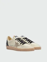 Zapatillas Golden Goose modelo Ballstar confeccionadas en cuero nappa color crema, con estrella laminada en el lateral, cordones negros y suela de goma con efecto desgastado.