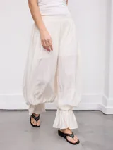 Pantalón de calce amplio estilo bombacho en color blanco, con cintura elástica fruncida y diseño abullonado en las piernas que finaliza en volados en los tobillos.
