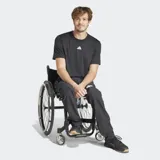 Pantalón deportivo negro de corte clásico, diseñado para deportistas en silla de ruedas. Presenta cintura elástica, tecnología transpirable AEROREADY y puños ajustables con cordón.