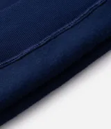 Buzo con capucha de color azul marino, confeccionado en tejido fleece. Presenta un diseño de manga larga con bolsillo tipo canguro y una estampa artística en la espalda que representa la silueta de Spider-Man con efecto de telaraña.