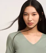 Blusa básica de manga corta con cuello en V, confeccionada en tejido de viscosa con elastano. Presenta un diseño liso y corte ajustado.