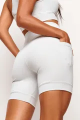 Short tipo biker de tiro alto, diseñado para running y entrenamiento. Confeccionado en tejido técnico de alta performance con bolsillos laterales funcionales y bolsillo interno en la cintura. Presenta detalles reflectivos y costuras estratégicas para mayor libertad de movimiento.