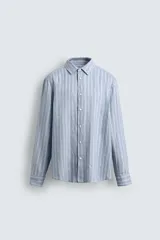 Camisa de hombre de manga larga, cuello italiano y corte regular fit, confeccionada en tejido de lino a rayas verticales azules y blancas.