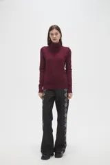 Polera de lyocell color negro, con cuello alto y ajuste al cuerpo, de manga larga.