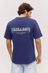 Remera blanca de algodón, de corte holgado y mangas cortas, con pequeño estampado azul en el pecho.
