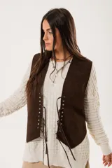 Chaleco marrón de gamuza con cordones laterales y tachas plateadas.