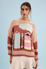 Buzo de algodón tejido a mano, de calce relajado y cuello redondo, con diseño gráfico inspirado en carpas de playa y franjas horizontales en tonos rosado, marrón, celeste y amarillo.