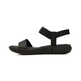 Sandalias planas Korium Confort modelo Agata, color negro, con tiras elásticas cruzadas en el empeine y ajuste en el talón. Suela flexible y diseño ergonómico para uso diario.