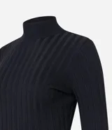 Polera color camel de punto acanalado, con cuello alto y mangas largas.