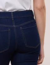 Jean skinny de tiro medio y calce ajustado, color azul clásico, con diseño de cinco bolsillos y largo al tobillo.