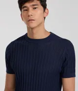 Remera masculina de algodón con textura acanalada y efecto punto. Presenta un diseño de corte regular, cuello redondo y manga corta.