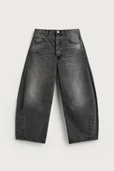 Jeans de denim de algodón color gris con efecto lavado, de corte relaxed barrel fit y tiro medio. Presenta diseño amplio con pinzas en las rodillas y costuras curvas, cierre frontal con botones y cinco bolsillos tradicionales.