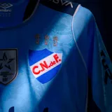 Camiseta de fútbol Umbro del Club Nacional de Football, edición especial en color celeste con detalles en azul marino y blanco. Incluye logo de Umbro, escudo del club, sponsor Antel en el pecho y distintivos oficiales.