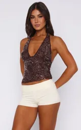 Top marrón con lentejuelas y espalda descubierta, con cuello halter y escote en V pronunciado.