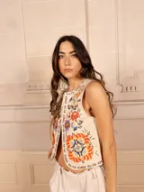 Chaleco negro con bordado floral multicolor, sin mangas y corte recto.