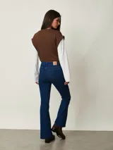 Jean de corte bootcut color azul oscuro, con tiro medio, bolsillos clásicos y cierre frontal con botón y cremallera.